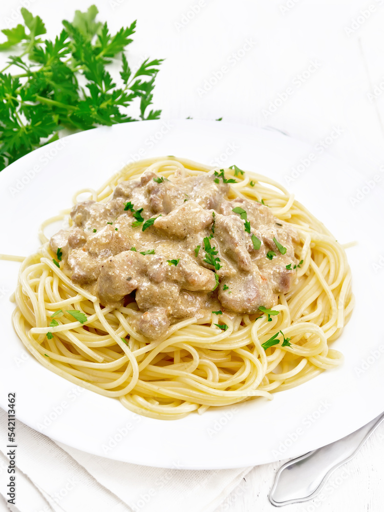 Meat in creamy sauce with spaghetti on white board Meat in creamy sauce with spaghetti on white board