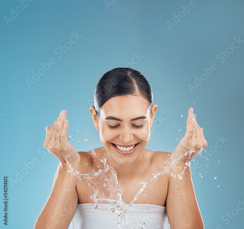 Woman water splash face, cleaning and wellness, shower and glowing skincare on mockup studio blue background. Happy young girl facial beauty, water drop and washing face, natural body and self care