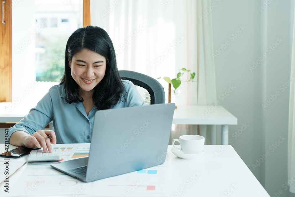 financial, Planning, Marketing and Accounting, portrait of Asian employee checking financial statements using documents and calculators and computer at work financial, Planning, Marketing and Accounting, portrait of Asian employee checking financial statements using documents and calculators and computer at work