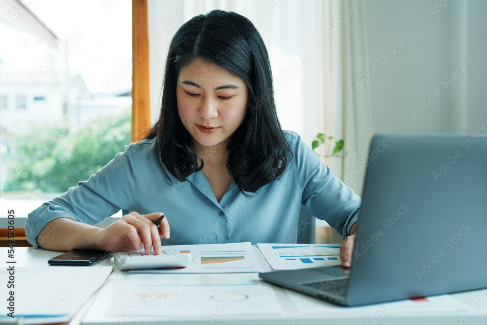 financial, Planning, Marketing and Accounting, portrait of Asian employee checking financial statements using documents and calculators and computer at work financial, Planning, Marketing and Accounting, portrait of Asian employee checking financial statements using documents and calculators and computer at work