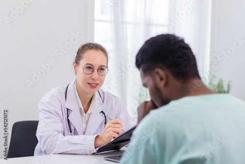 Doctor holding checklist and talking to man Patient at hospital. Physician examining male patient in hospital room.