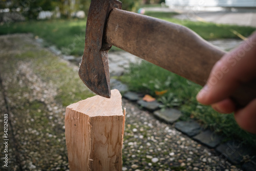 a piece of wood is split with an axe © karegg