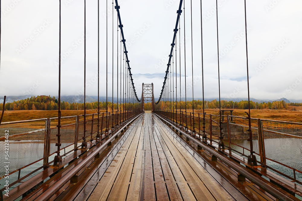 Obraz premium suspension bridge across the river, altai view dilapidated old bridge crossing