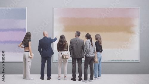 People looking at paintings at the art exhibition
