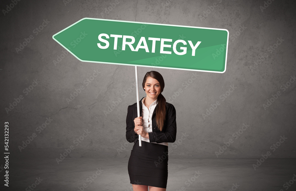Young business person in casual holding road sign Young business person in casual holding road sign