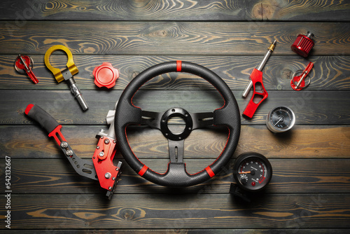 Sport car tuning accessories on the wooden workbench flat lay background.