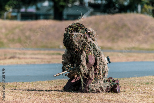 ギリースーツを着た狙撃手（sniper in ghillie suit with presicion rifle） photo