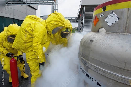 Firefighters in protective chemical hazmat suits stop a simulated leak of the dangerous chemical substance ethylene oxide photo