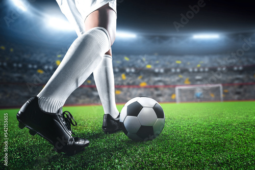 Soccer player in action on sport stadium background, kicking ball