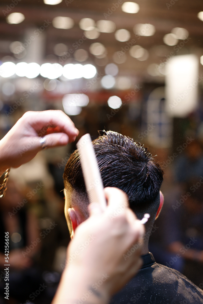 peluquero peinando el pelo a un cliente en el salón