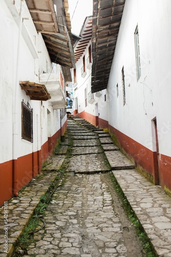 Vertical shot of a small cobblestone street in Cuetzalan del Progreso town, Mexico photo