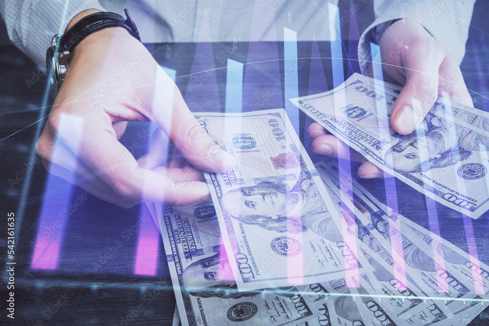 Multi exposure of financial graph drawing hologram and USA dollars bills and man hands. Analysis concept. Multi exposure of financial graph drawing hologram and USA dollars bills and man hands. Analysis concept.