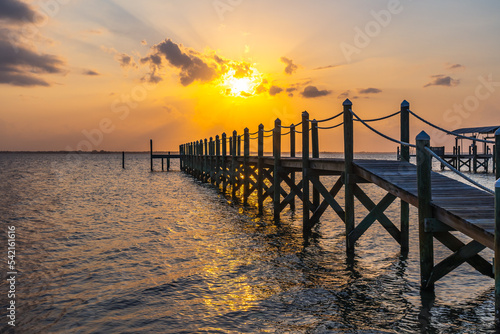 View of a yellow sunset over Indian River  wooden pillars of the old pier near the coast as a typical view of Florida
