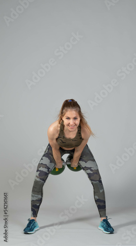 Training with kettlebells, a young athlete performs exercises with kettlebells, kettlebell lifting for the tone of the whole body