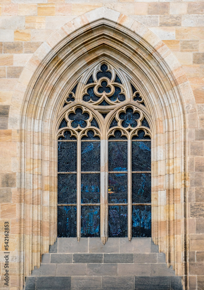 Gothic arched window with stained glass at The St. Vitus Cathedral in Prague Castle, outside view. Stone decor elements of Christian Catholic temple in medieval style in Praga, Czech Republic.
