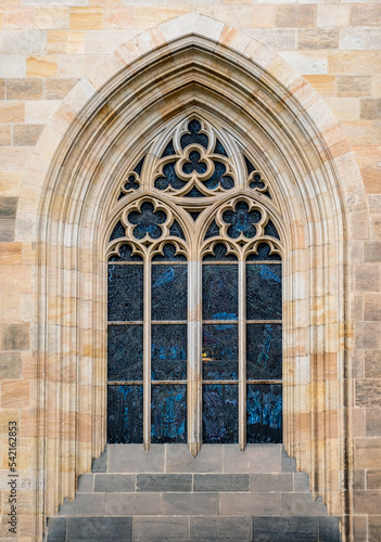 Gothic arched window with stained glass at The St. Vitus Cathedral in Prague Castle  outside view. Stone decor elements of Christian Catholic temple in medieval style in Praga  Czech Republic.