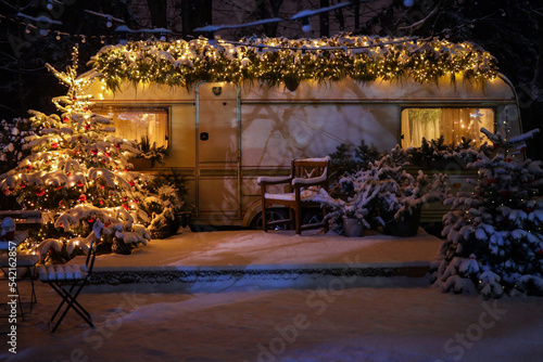 Cozy Christmas atmosphere. Happy New Year 2023. New Year background. The concept of the beginning of the year. Christmas camping. The trailer is decorated with Christmas decor. Festive atmosphere.