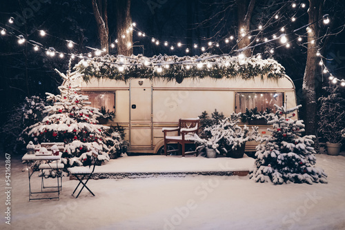 Cozy Christmas atmosphere. Happy New Year 2023. New Year background. The concept of the beginning of the year. Christmas camping. The trailer is decorated with Christmas decor. Festive atmosphere.