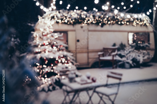 Cozy Christmas atmosphere. Happy New Year 2023. New Year background. The concept of the beginning of the year. Christmas camping. The trailer is decorated with Christmas decor. Festive atmosphere.