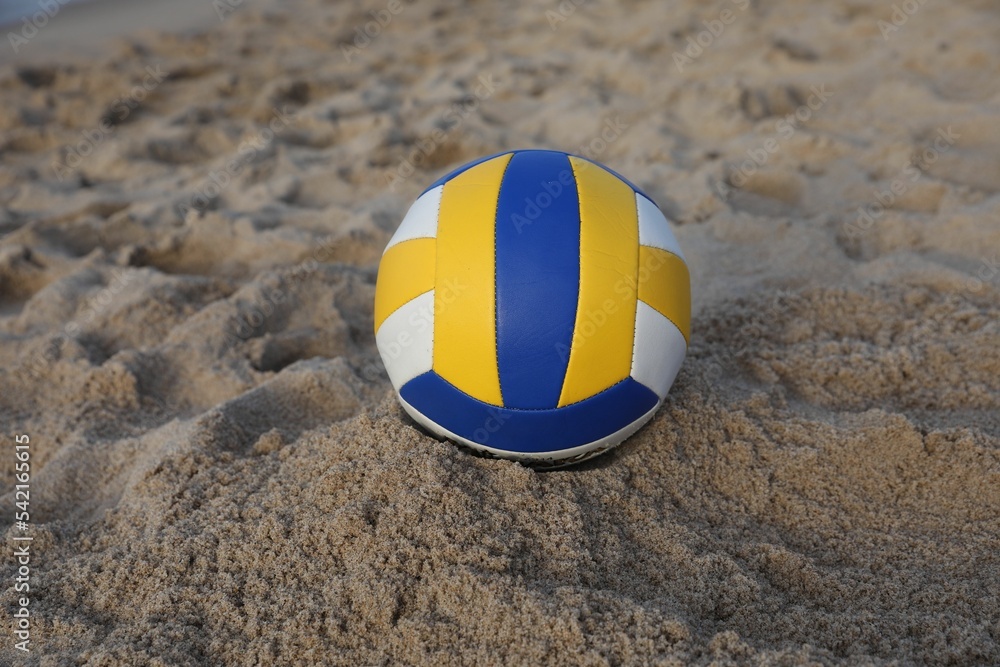Colorful leather volleyball ball on sandy beach