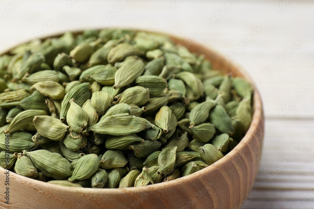 Bowl with dry cardamom on wooden table, closeup Bowl with dry cardamom on wooden table, closeup