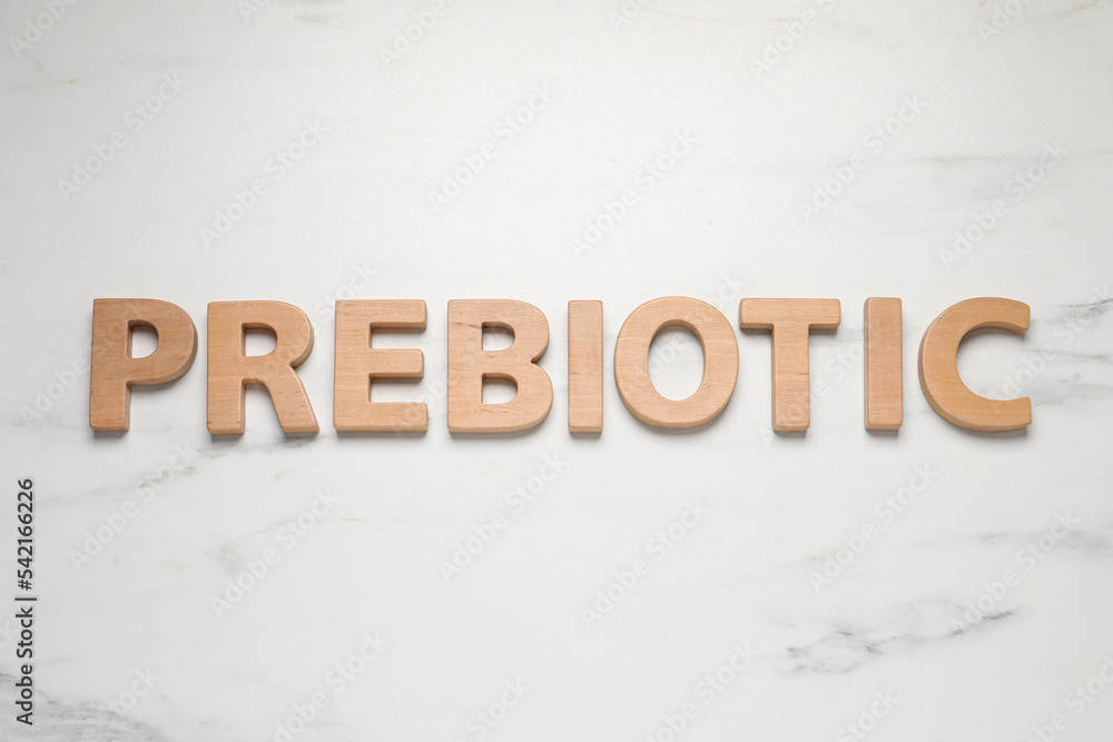 Word Prebiotic made of wooden letters on white marble table, flat lay Word Prebiotic made of wooden letters on white marble table, flat lay