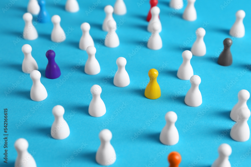 Colorful pawns on light blue background. Social inclusion concept