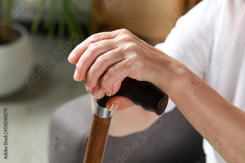 Elderly woman with walking cane indoors, closeup. Home care service