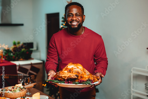 A man holding a turkey in his hand ready to place on the table.