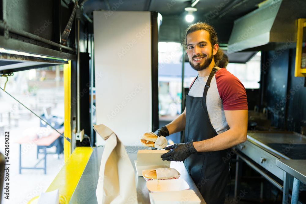 Hispanic chef smiling while serving fast food at the food truck Hispanic chef smiling while serving fast food at the food truck