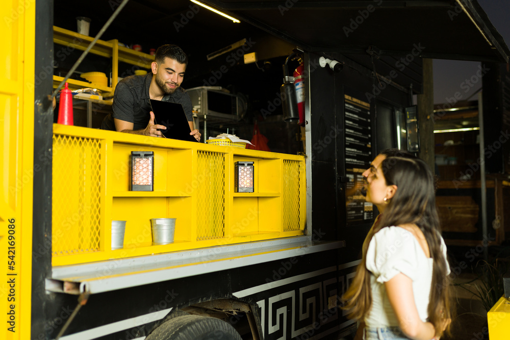 Food truck cook showing the fast food menu to customers Stock Photo