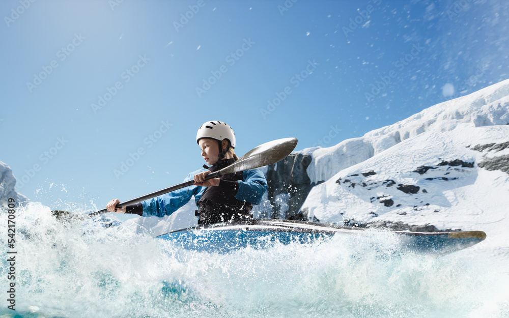 Woman in a kayak sails on a mountain river. Whitewater kayaking, extreme kayaking.