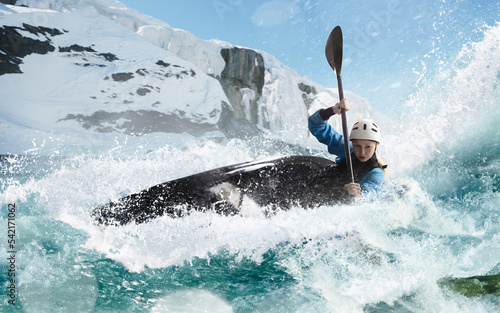 Woman in a kayak sails on a mountain river. Whitewater kayaking, extreme kayaking.