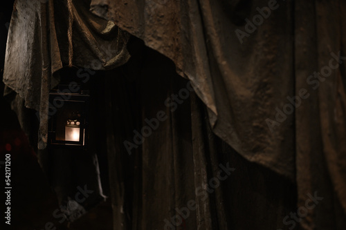 Capuchin habit background and a lantern bearing lighted candle