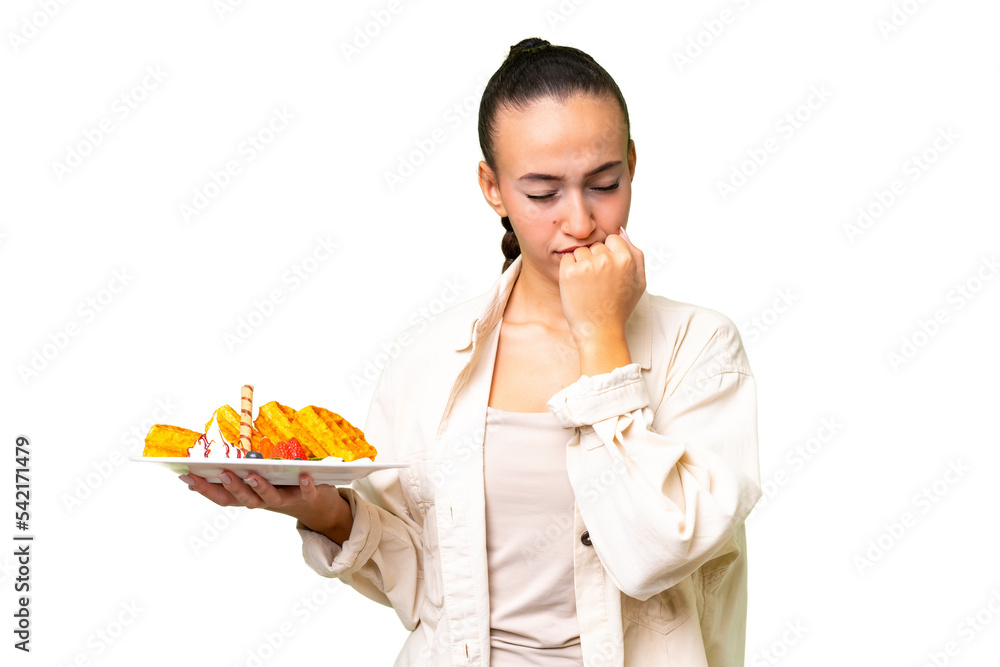 Young Arab woman holding waffles over isolated background having doubts Young Arab woman holding waffles over isolated background having doubts