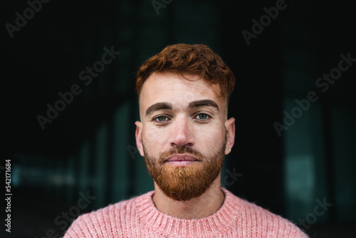 Portrait of young man with red hair looking at the camera