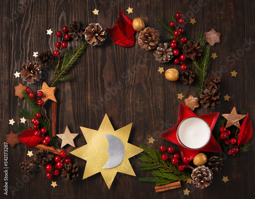 Winter Solstice Day, December 21. Sun and Moon Symbol, Christmas trees, pine cones, paddub branches with red berries, candle on dark wooden background, top view. photo