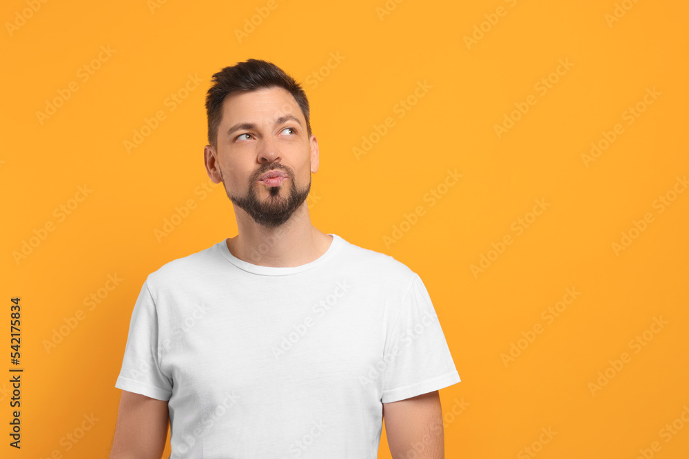 Handsome man blowing kiss on orange background. Space for text Handsome man blowing kiss on orange background. Space for text