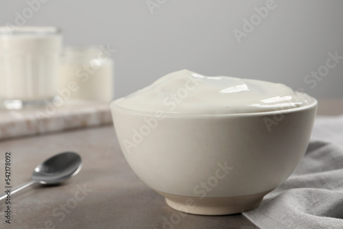 Bowl with delicious organic yogurt on grey table, closeup