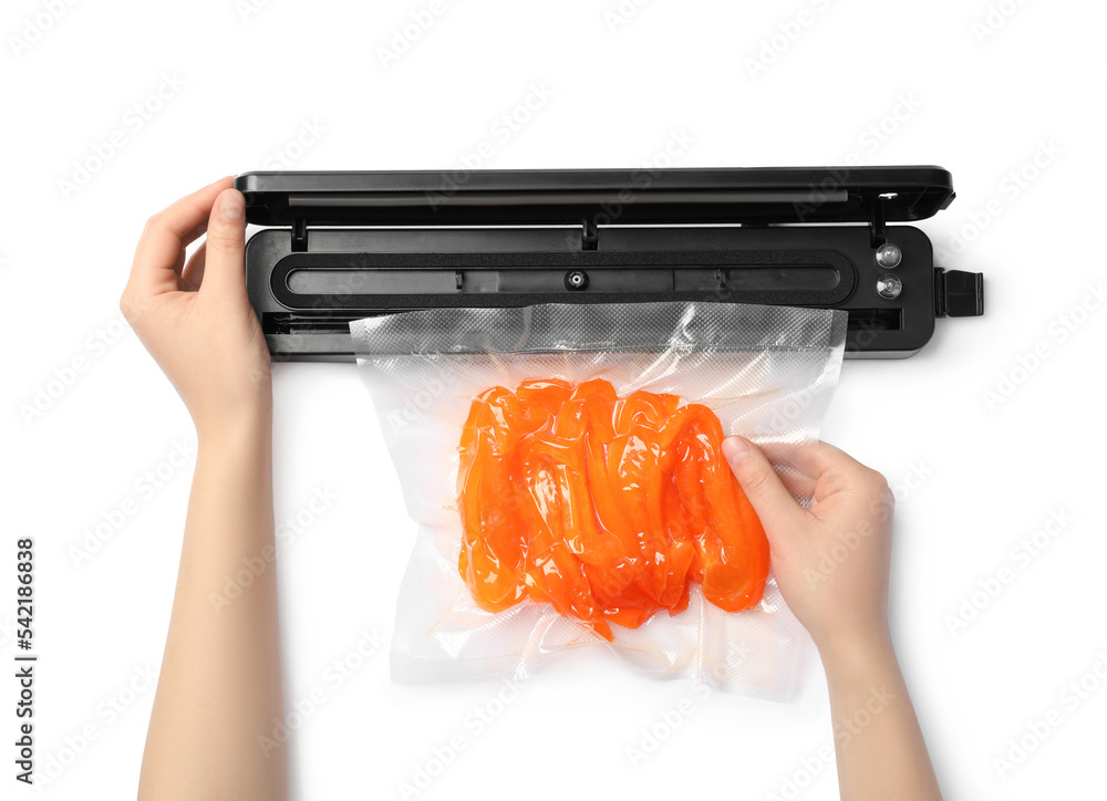 Woman using sealer for vacuum packing with plastic bag of bell pepper