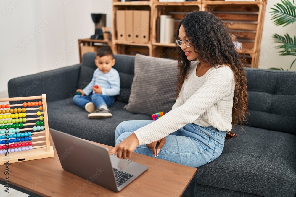 Mother and son having educational therapy using laptop at pedagogue center Mother and son having educational therapy using laptop at pedagogue center