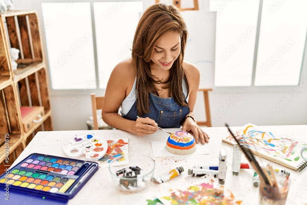 Young hispanic artist woman smiling happy drawing at art studio. Young hispanic artist woman smiling happy drawing at art studio.