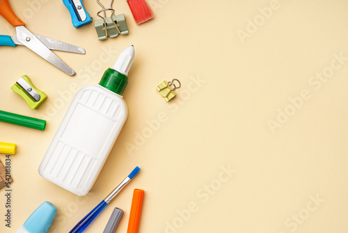 Composition with bottle of glue and different stationery on color background