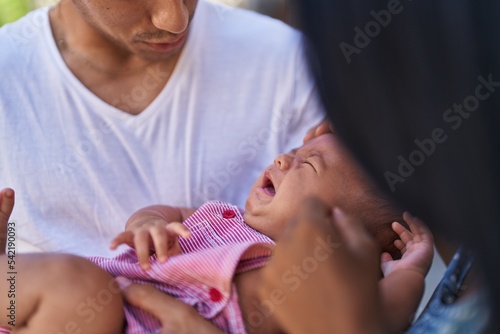 Hispanic family smiling confident hugging each other at street