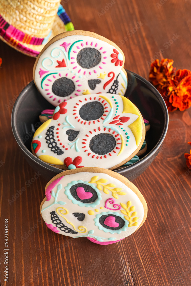 Bowl with skull shaped cookies on wooden background. El Dia de Muertos
