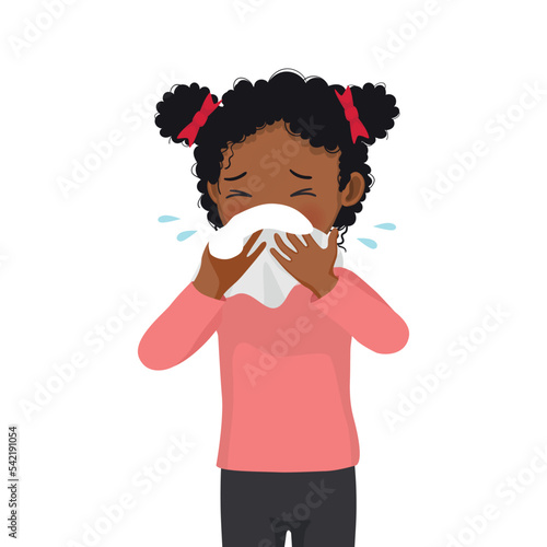 Cute little African girl sneezing with flu and cold allergic symptoms blowing nose into tissue paper 
