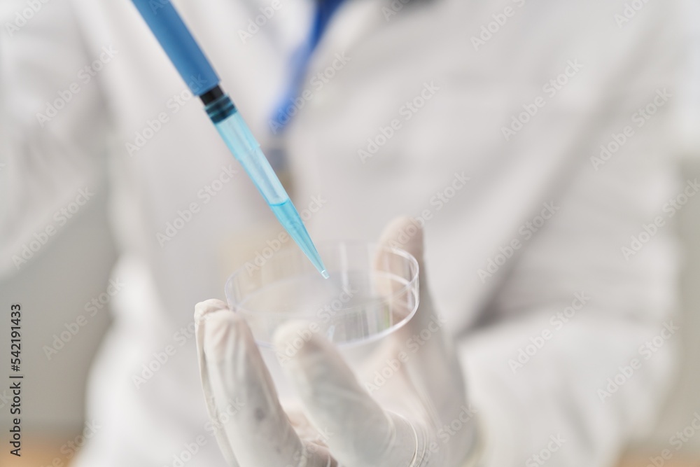 Young african american man wearing scientist uniform using pipette at laboratory Young african american man wearing scientist uniform using pipette at laboratory
