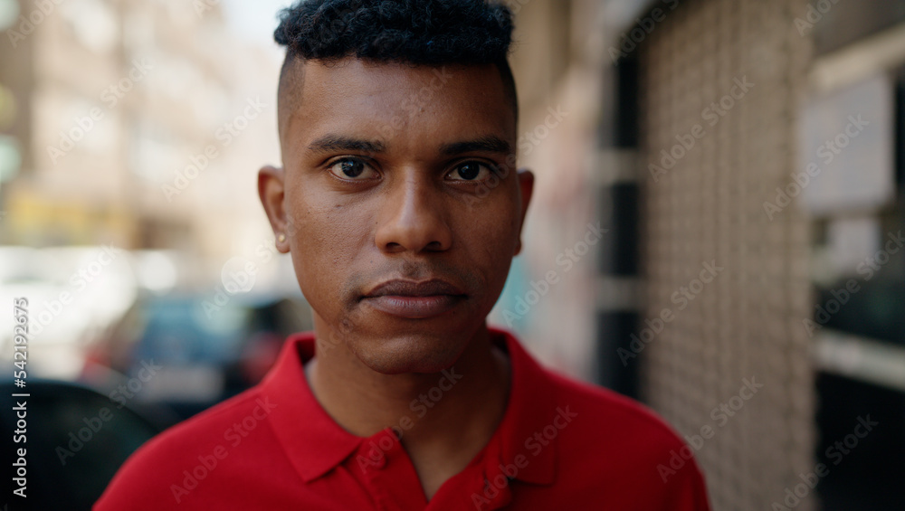 Young latin man with relaxed expression standing at street Young latin man with relaxed expression standing at street