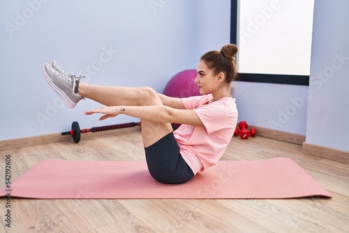 Young woman smiling confident training abs exercise at sport center