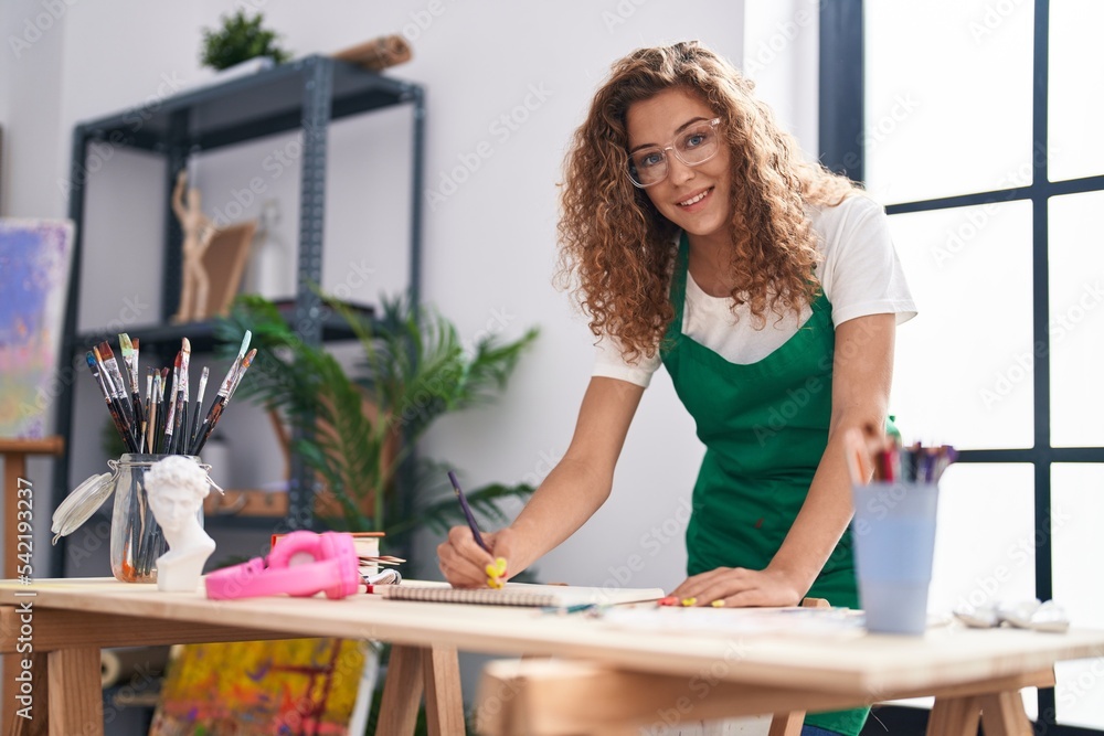 Young beautiful hispanic woman artist smiling confident drawing on notebook at art studio Young beautiful hispanic woman artist smiling confident drawing on notebook at art studio